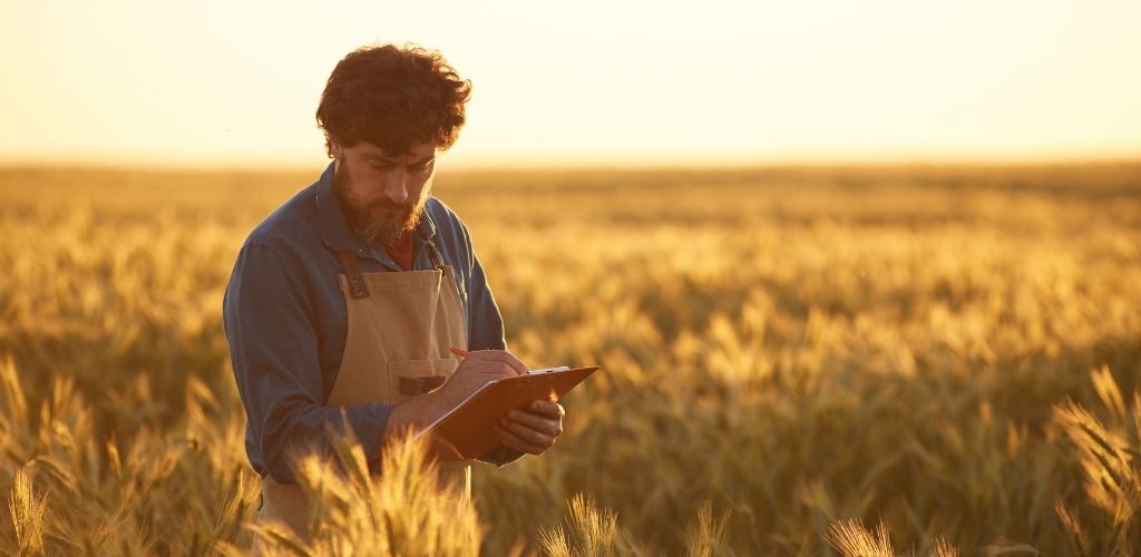 O agro não para: homem no campo planejando e analisando a safra